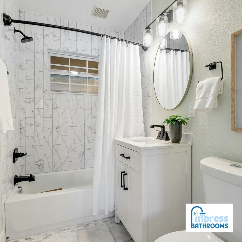 Bathroom renovations in Castle Hill showcasing a modern white design with a vanity, bathtub, and black fixtures for a sleek finish.